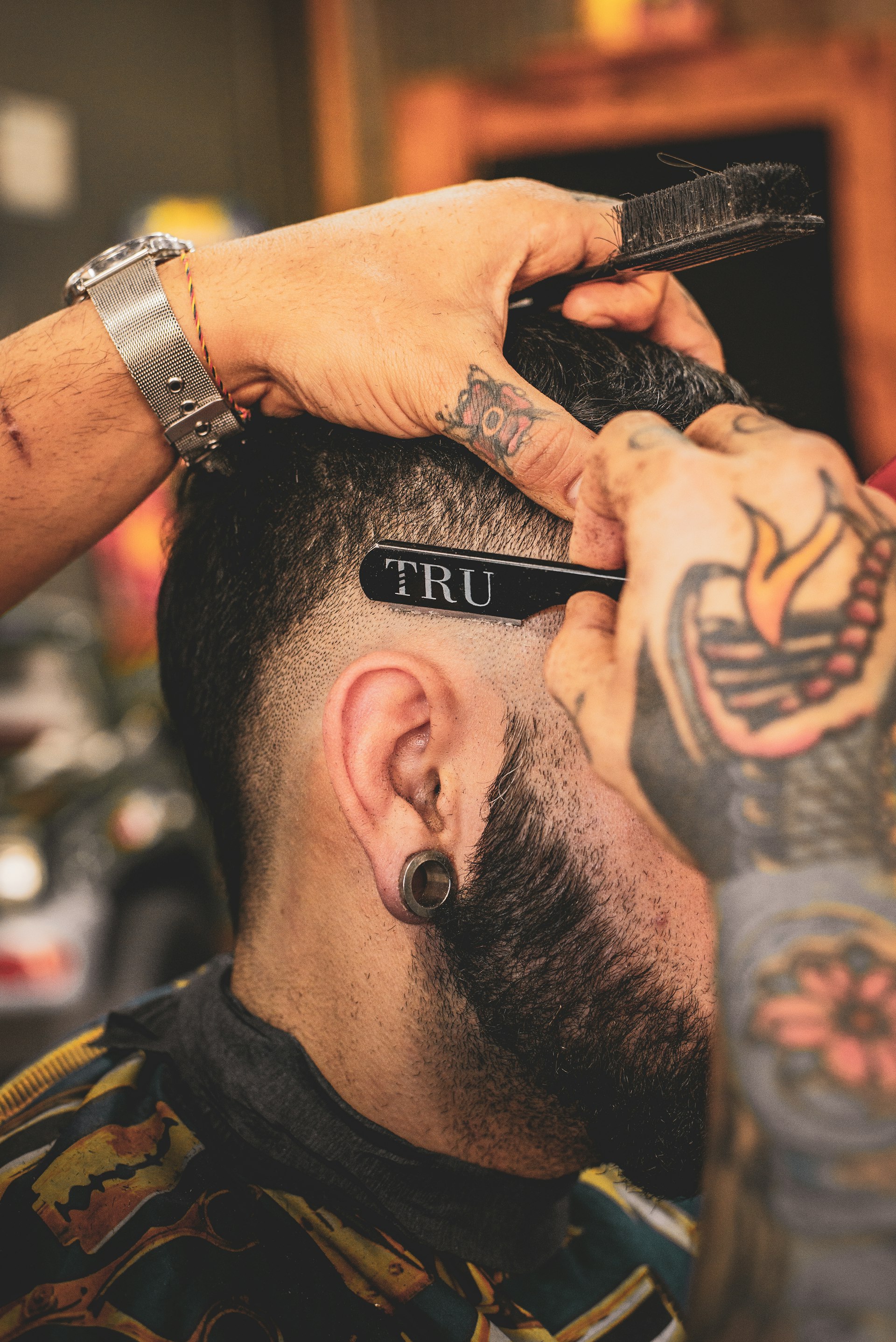 Barber giving a client a sharp fade inside Iron Cut Barbers